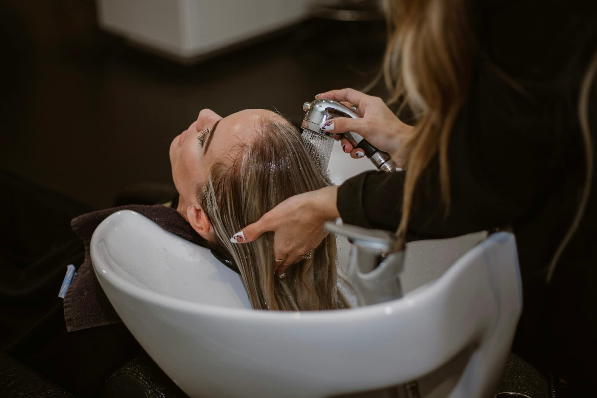 Coiffeuse en train de couper les cheveux d'une cliente en salon